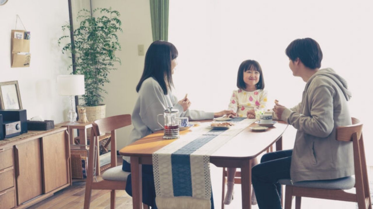 Uma mulher, uma criança e um homem tomando café da manhã. Eles estão felizes.